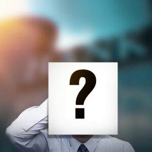 Businessman with a question-mark placard over his face symbolizing anonymity or uncertainty.