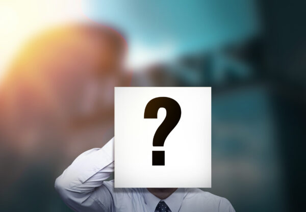 Businessman with a question-mark placard over his face symbolizing anonymity or uncertainty.