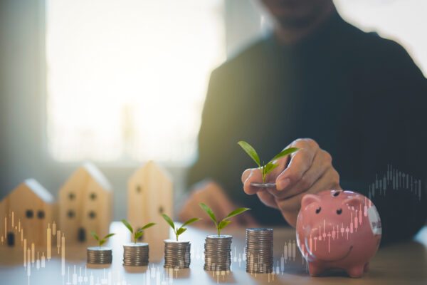Stacked coins sprouting seedlings beside a piggy bank, depicting financial growth.