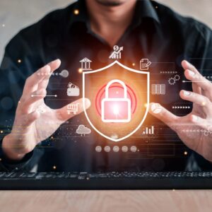 Businessperson cups hands around a glowing padlock hologram symbolizing cybersecurity protection.