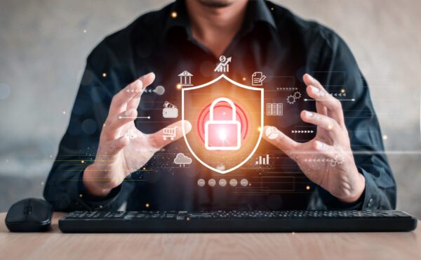 Businessperson cups hands around a glowing padlock hologram symbolizing cybersecurity protection.