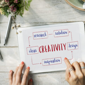 Tablet on desk showing a mind-map with “CREATIVITY” linked to ideas, research, and design.