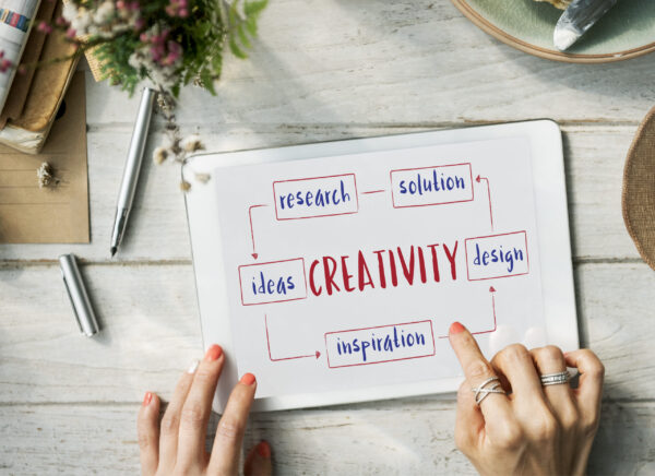 Tablet on desk showing a mind-map with “CREATIVITY” linked to ideas, research, and design.